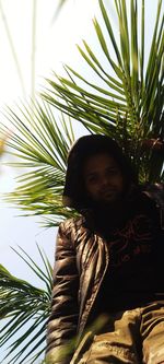 Portrait of young man with palm tree