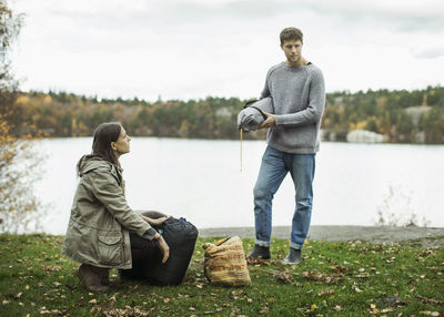 Couple with camping luggage on lakeshore