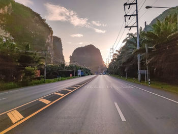 Road leading towards bridge against sky