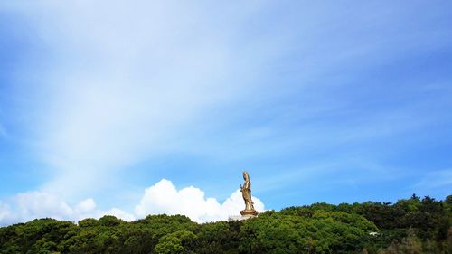 Low angle view of statue against blue sky