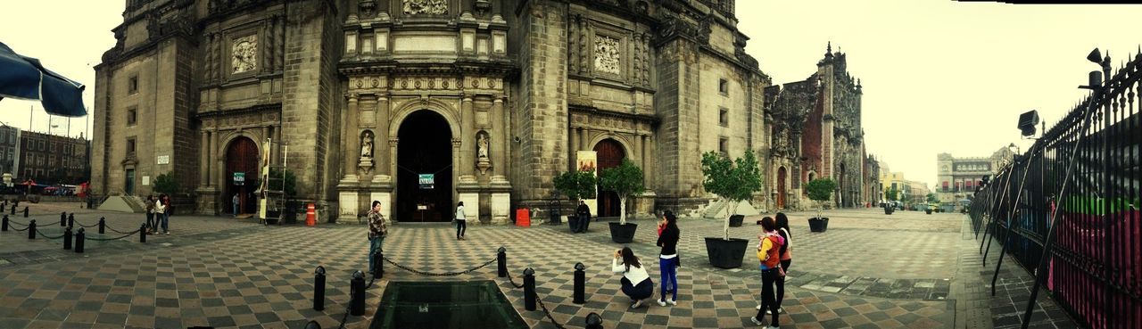 architecture, building exterior, built structure, city, street, walking, arch, clear sky, city life, large group of people, men, the way forward, person, incidental people, cobblestone, transportation, travel destinations, road, city street