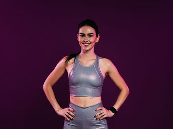 Young woman standing against black background