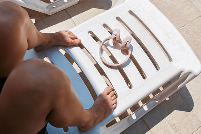 Female legs and wireless headphones on the beach lounger in the hotel