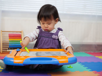 Baby girl playing with toys at home