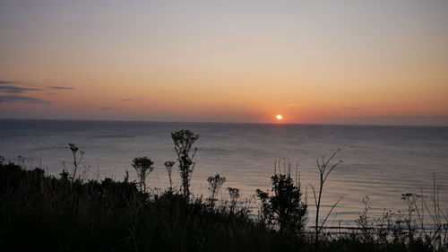 Scenic view of sea against romantic sky at sunset