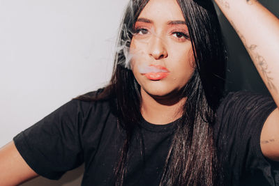 Portrait of young woman against white background