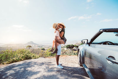 Full length of woman standing on car against sky