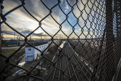 Chainlink fence against sky in city