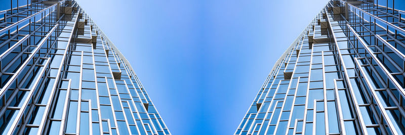 Low angle view of modern buildings against clear blue sky