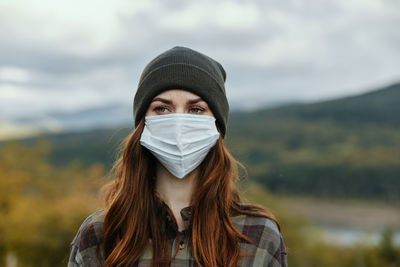 Portrait of young woman wearing hat outdoors