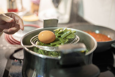 Old woman finger pointing to cooked boiled eggs and green beans ready to eat. healthy food concept.
