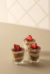 Tiramisu cupcake small cups of tiramisu dessert with strawberry topping, copy space for text