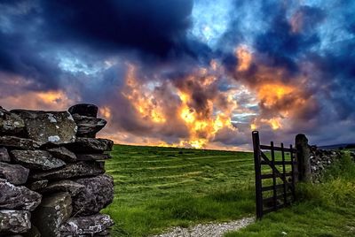 Scenic view of grassy field against cloudy sky