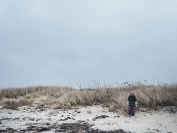 Girl standing at sand dunes