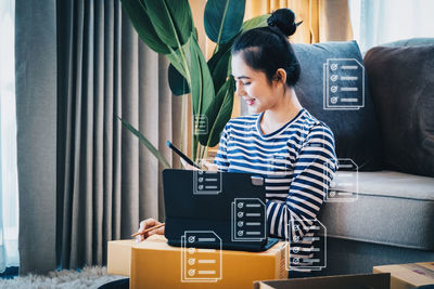 Side view of woman using laptop at home