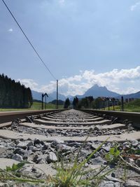 Surface level of railroad track on field against sky