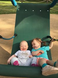 Cute siblings resting in hammock at park