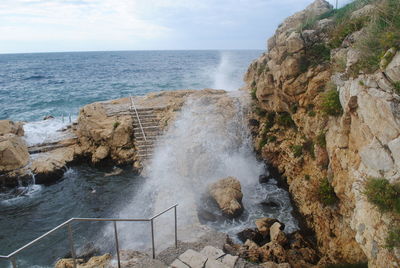 Rock formations in sea against sky