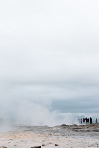 People on beach against sky