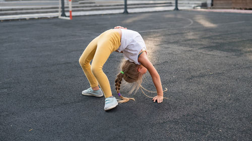 Low section of woman exercising on road