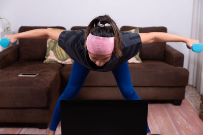 Portrait of young woman exercising in gym