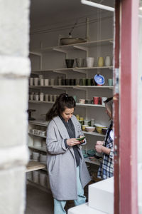 Female potters discussing ceramics plate at store