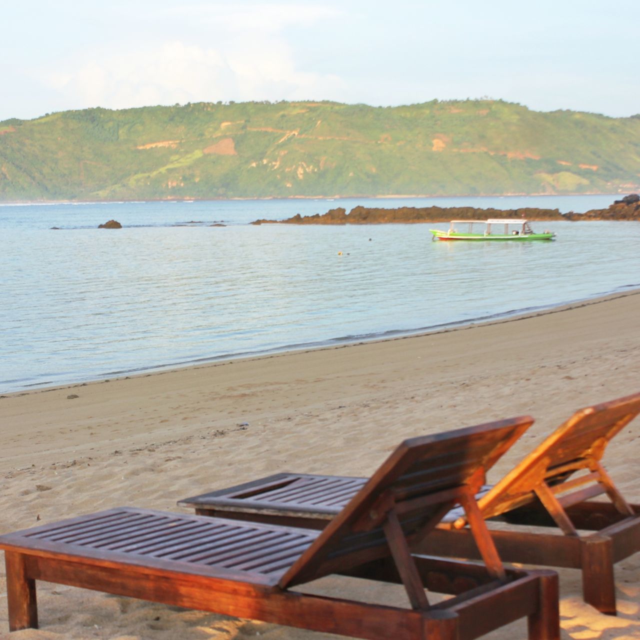 CHAIRS AND TABLE ON BEACH AGAINST SKY