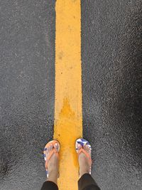 Low section of person standing on road