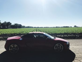 Car on field against clear sky