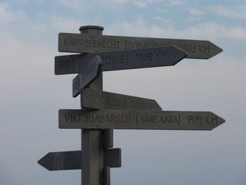 Low angle view of sign board against sky