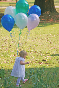 Full length of girl holding balloons