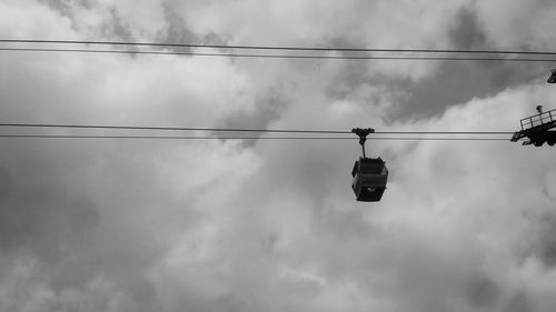 Low angle view of cable car against cloudy sky