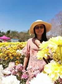 Woman standing on yellow flowering plants