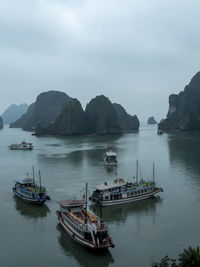 Boats moored in sea against sky