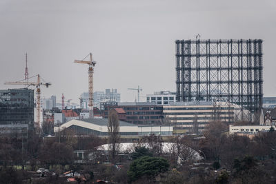 Construction site by buildings against sky