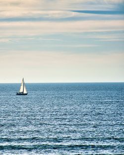 Sailboat in sea against sky