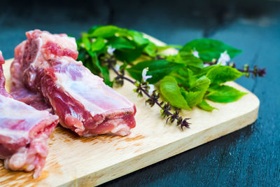 Raw meat and leaves on cutting board