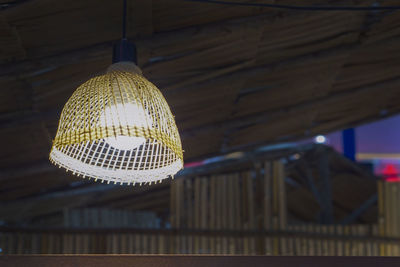 Low angle view of illuminated pendant light hanging on ceiling