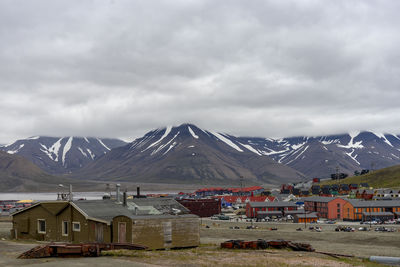 Houses by snowcapped mountains against sky svalbard 