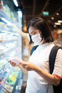 Woman looking away while standing at store