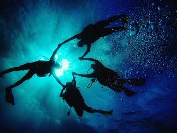 Low angle view of people scuba diving in sea