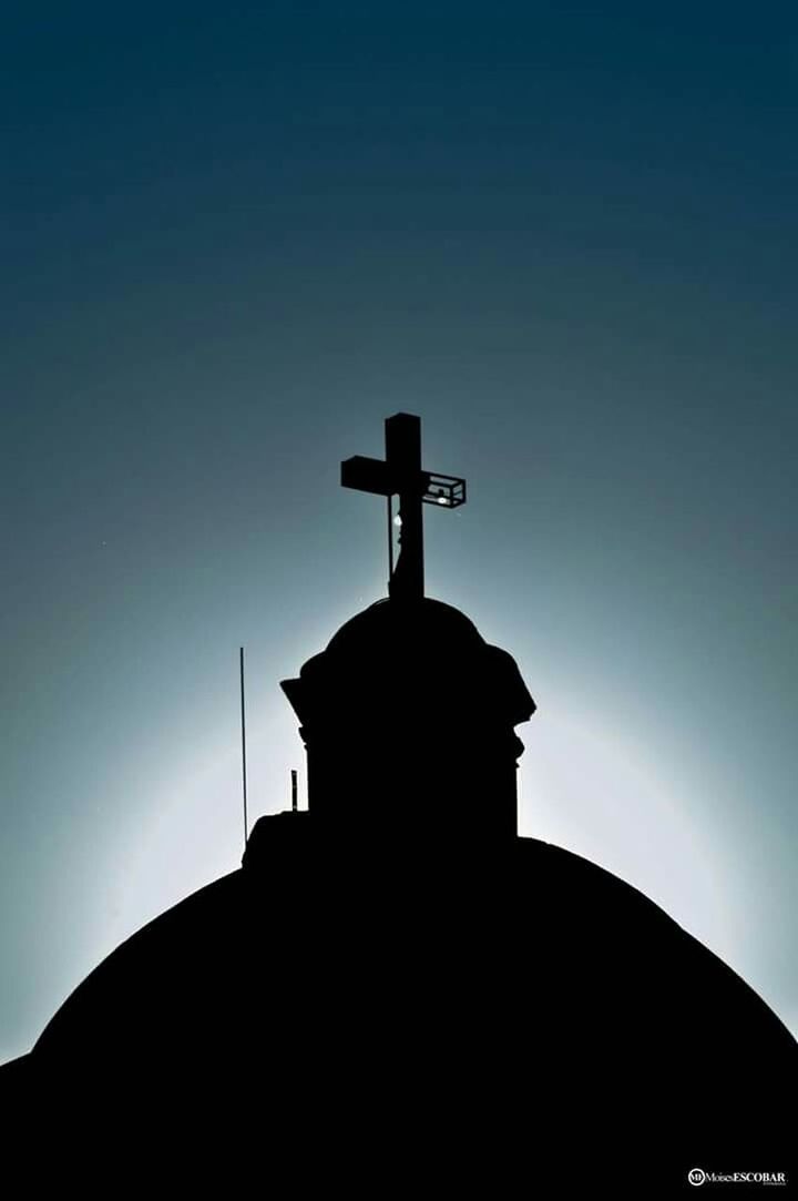 silhouette, religion, spirituality, place of worship, low angle view, cross, church, built structure, architecture, building exterior, statue, sky, copy space, sunset, human representation, sculpture, clear sky, dusk