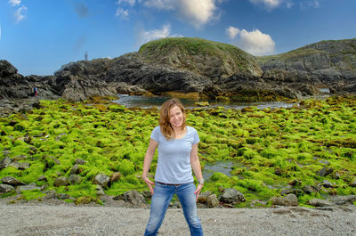Portrait of smiling woman standing on mountain against sky