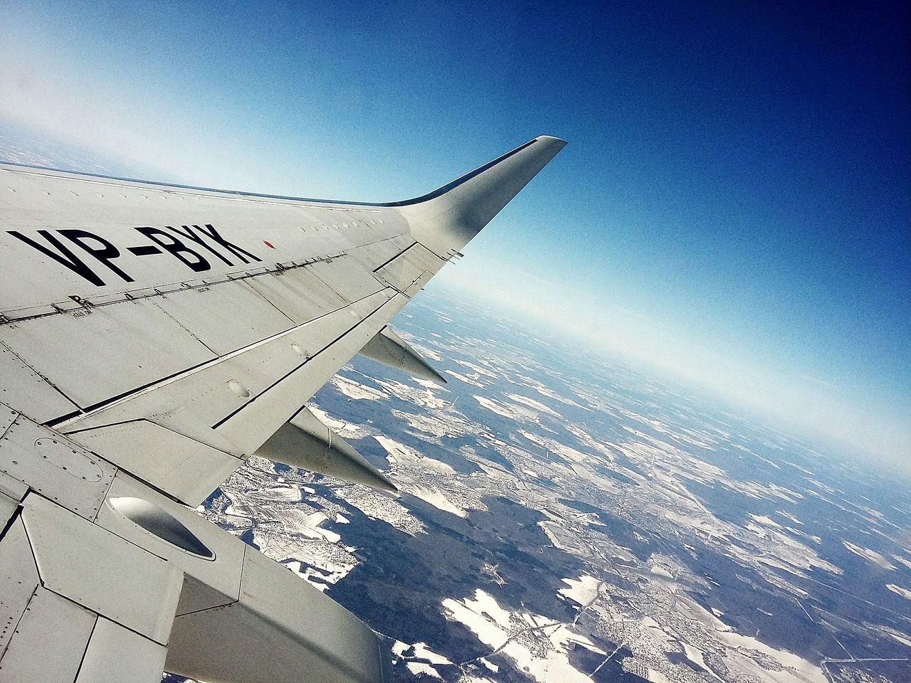 flying, airplane, air vehicle, blue, sky, aerial view, travel, aircraft wing, mountain, transportation, scenics, mid-air, part of, beauty in nature, cropped, text, nature, day, outdoors, cloud - sky