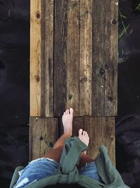 Low section of woman on wooden built structure