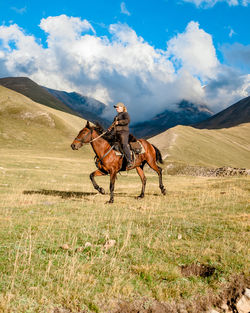 Horses on field against mountain