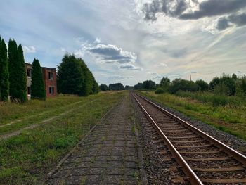 Railroad track amidst trees against sky