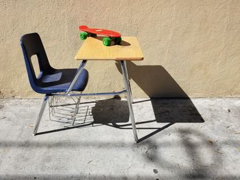 High angle view of chair on table against wall