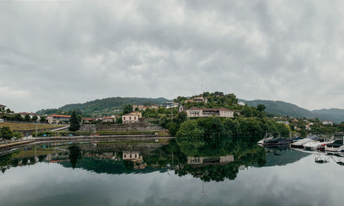 Buildings by lake against sky