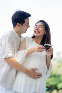 Young couple standing against clear sky